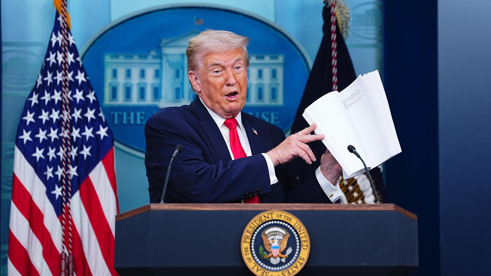 US-Präsident Donald Trump blättert in einem Buch über die Erfolge seiner Regierung, aufgenommen am 20.01.2026 in Washington (USA)