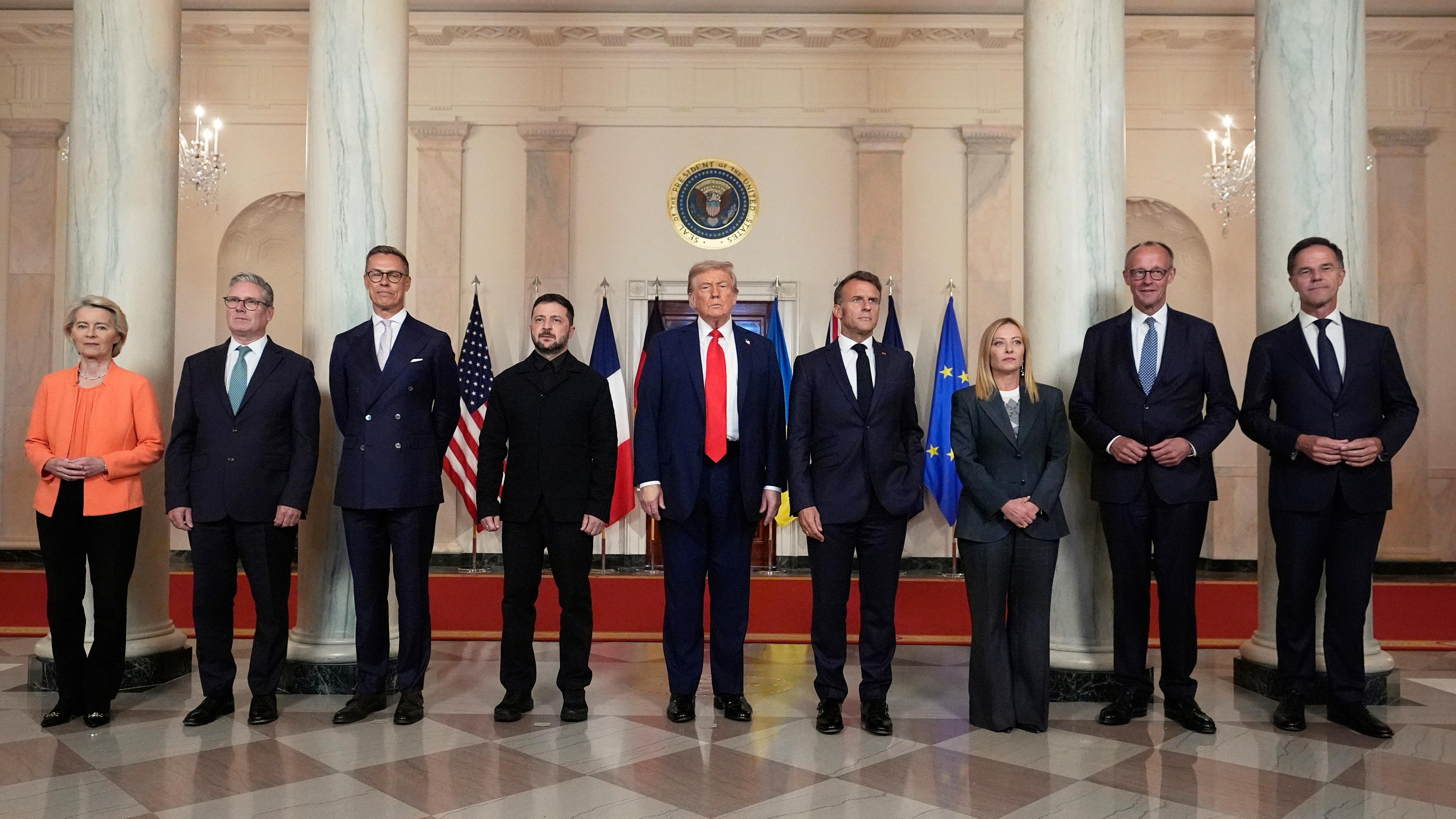 Die Präsidentin der Europäischen Kommission, Ursula von der Leyen (von links), der britische Premierminister Keir Starmer, der finnische Präsident Alexander Stubb, der ukrainische Präsident Wolodymyr Selenskyj, Präsident Donald Trump, der französische Präsident Emmanuel Macron, die italienische Premierministerin Giorgia Meloni, der deutsche Bundeskanzler Friedrich Merz und NATO-Generalsekretär Mark Rutte posieren für ein Gruppenfoto im Grand Foyer des Weißen Hauses.