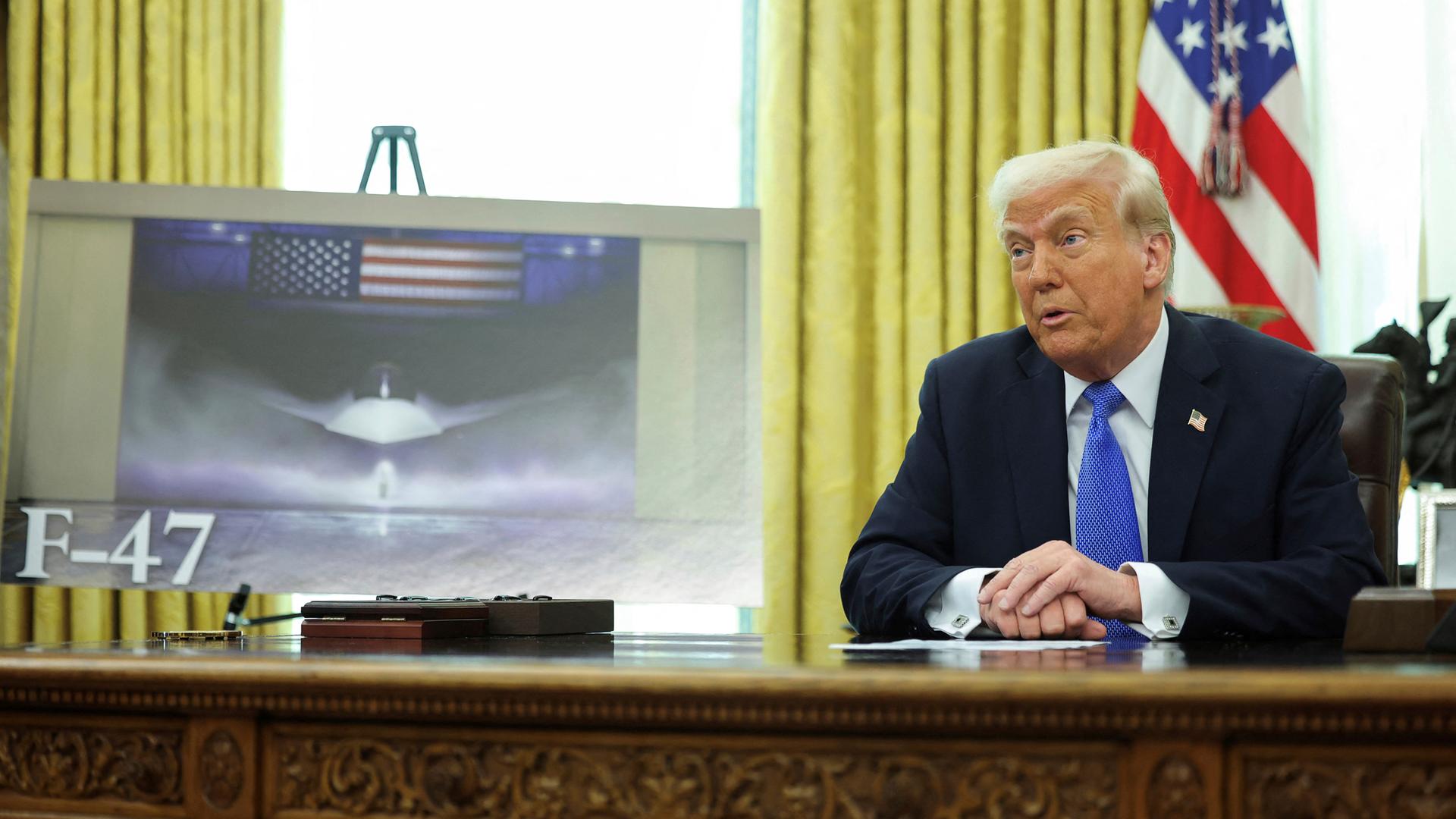 Präsident Donald Trump spricht, während bei einer Veranstaltung im Oval Office des Weißen Hauses in Washington ein Bild eines F-47-Kampfjets der sechsten Generation gezeigt wird