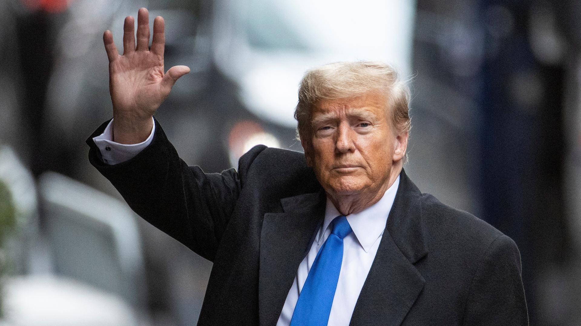 Der ehemalige US-Präsident Donald Trump hebt die Hand zum Gruß seiner Unterstützer.