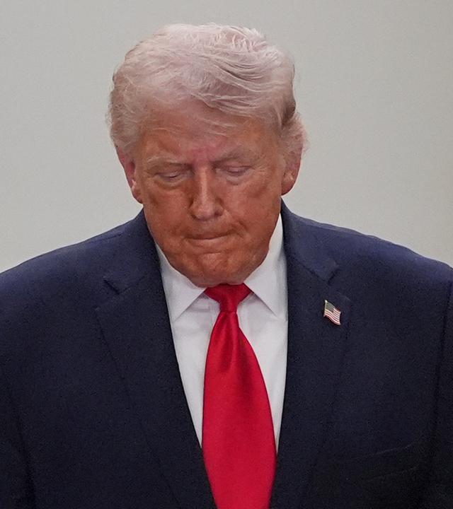 Donald Trump schaut nach unten zum Boden.