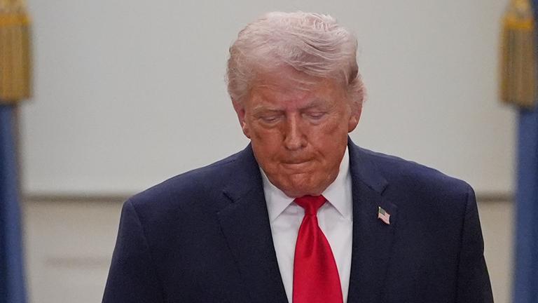 Donald Trump schaut nach unten zum Boden.