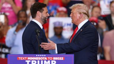 Donald Trump und sein Vizepräsidentschaftskandidat J.D. Vance begrüßen sich bei einer Wahlkampfveranstaltung.
