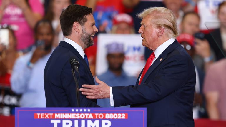 Donald Trump und sein Vizepräsidentschaftskandidat J.D. Vance begrüßen sich bei einer Wahlkampfveranstaltung.