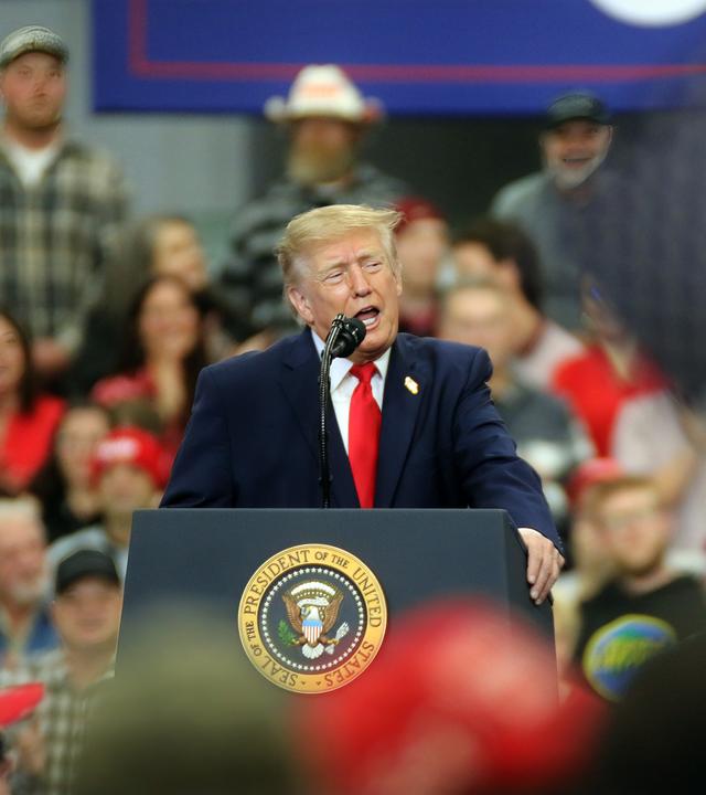 Donald Trump steht auf einer Bühne in einer Menschenmenge.