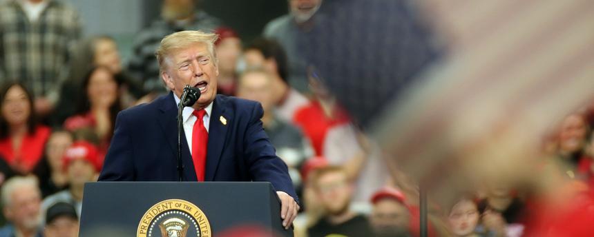 Donald Trump steht auf einer Bühne in einer Menschenmenge.