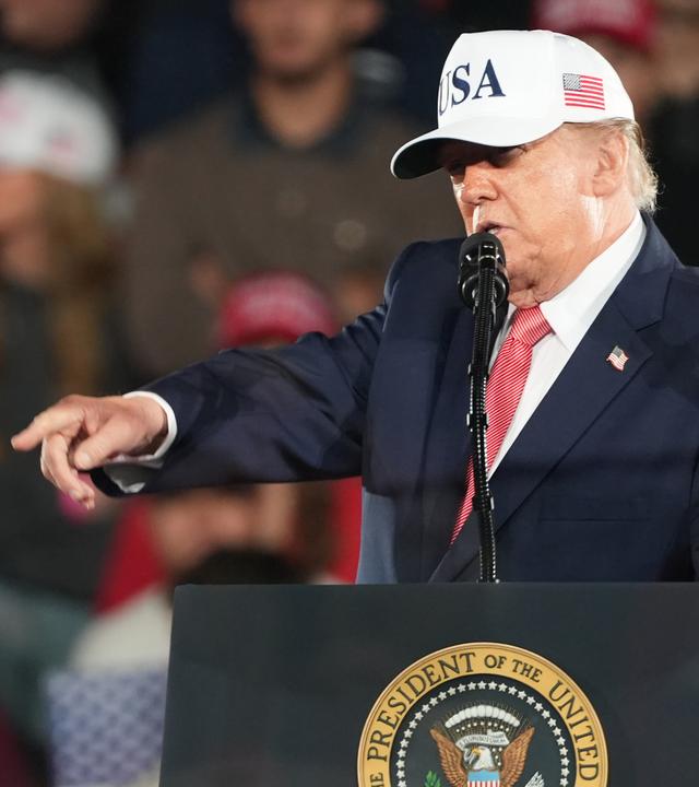 Donald Trump steht hinter einem Rednerpult auf einer Wahlkampfveranstaltung in North Carolina und zeigt in die Menge.