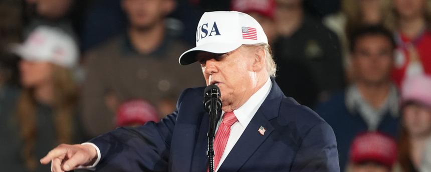 Donald Trump steht hinter einem Rednerpult auf einer Wahlkampfveranstaltung in North Carolina und zeigt in die Menge.
