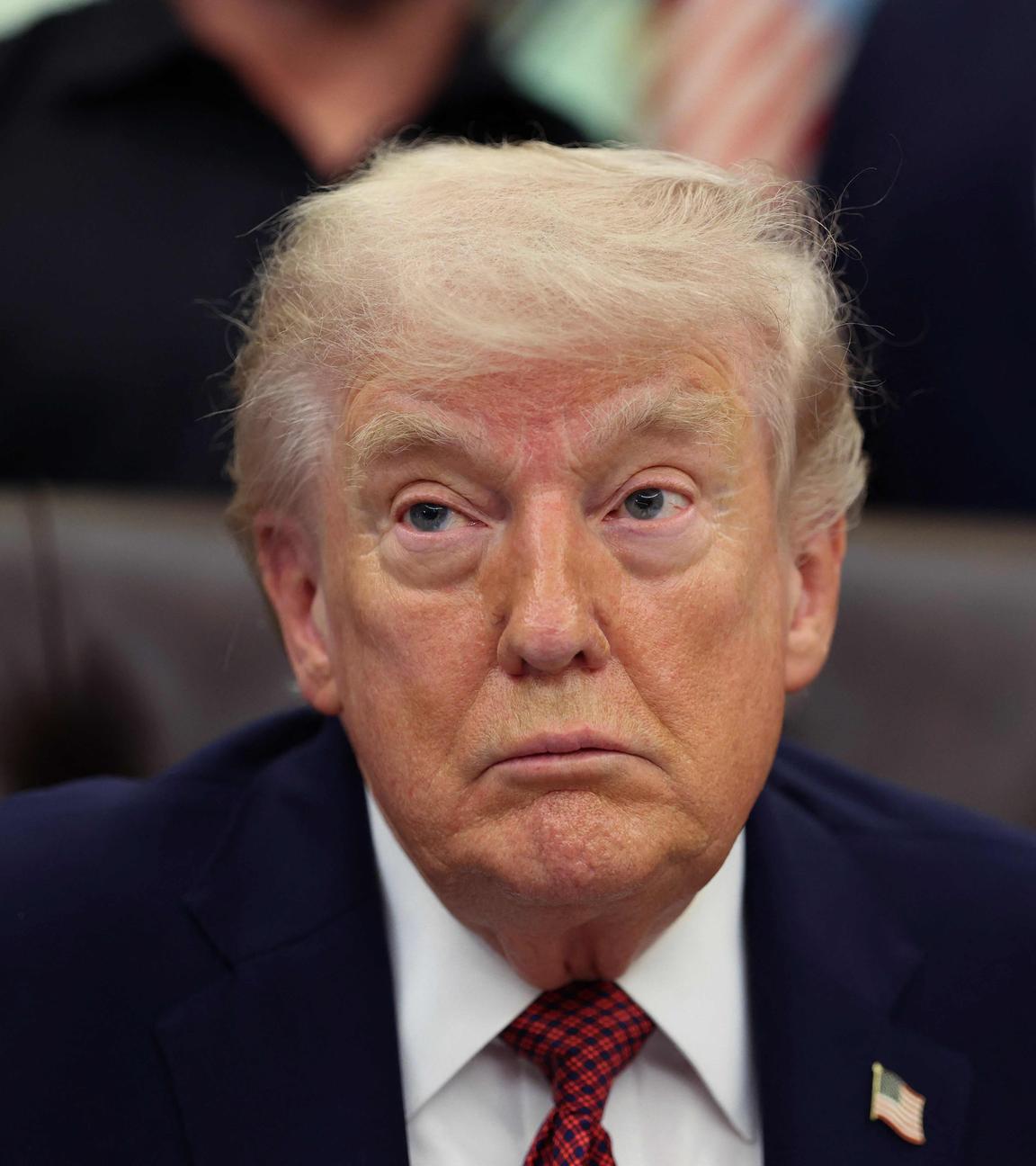 Donald Trump im Oval Office mit heruntergezogenen Mundwinkeln.