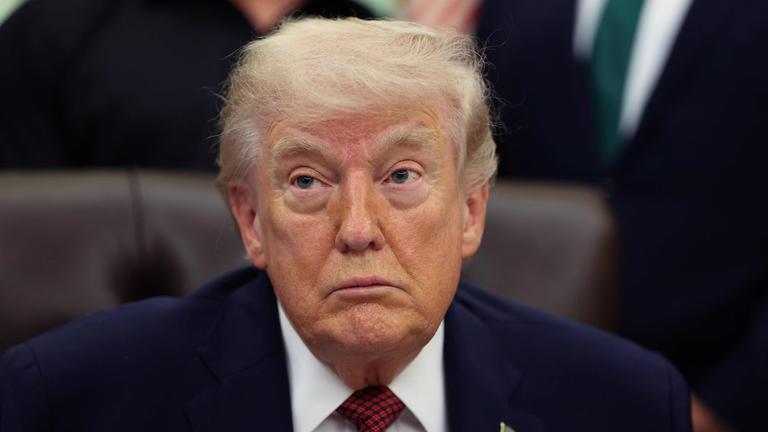 Donald Trump im Oval Office mit heruntergezogenen Mundwinkeln.