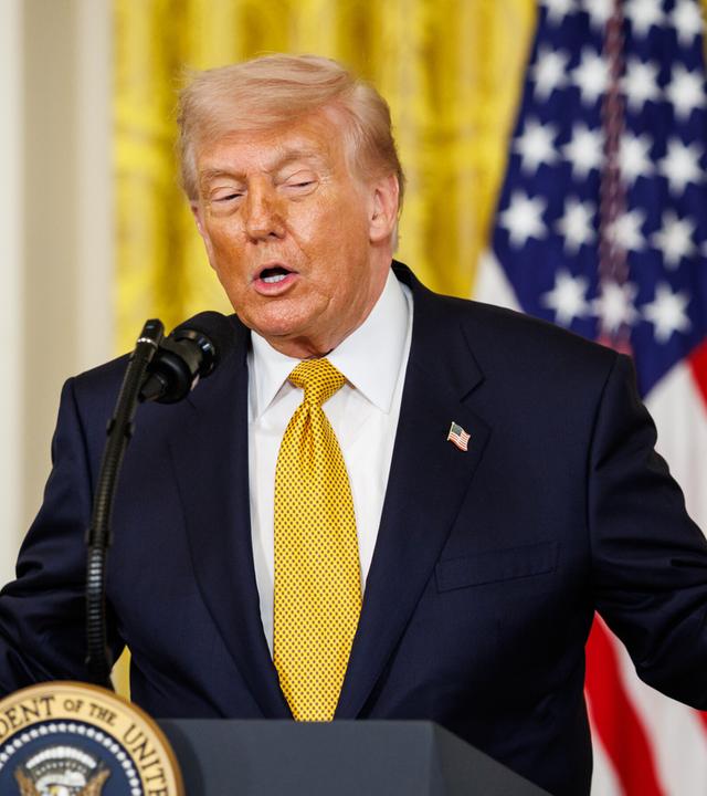 US-Präsident Donald Trump hebt beide Arme bei einer Rede.