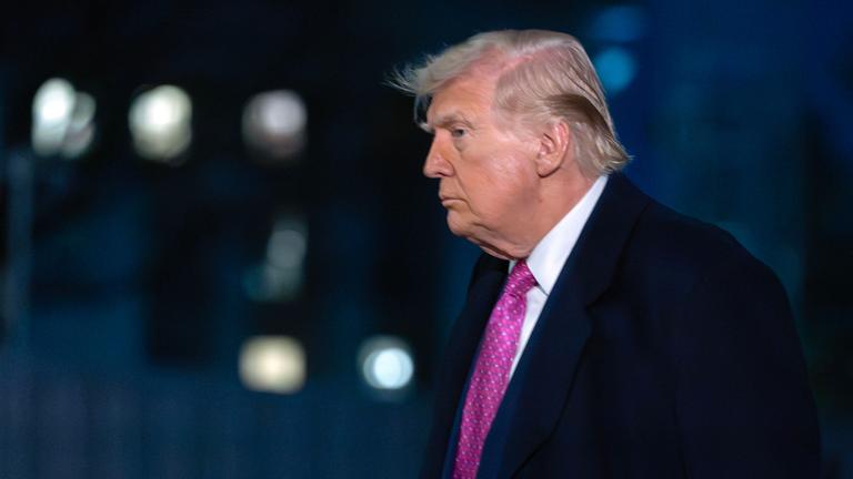 Präsident Donald Trump bei Dunkelheit von der Seite.