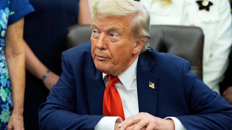 US-Präsident Donald Trump sitzt während einer Veranstaltung im Weißen Haus hinter seinem Schreibtisch im Oval Office.