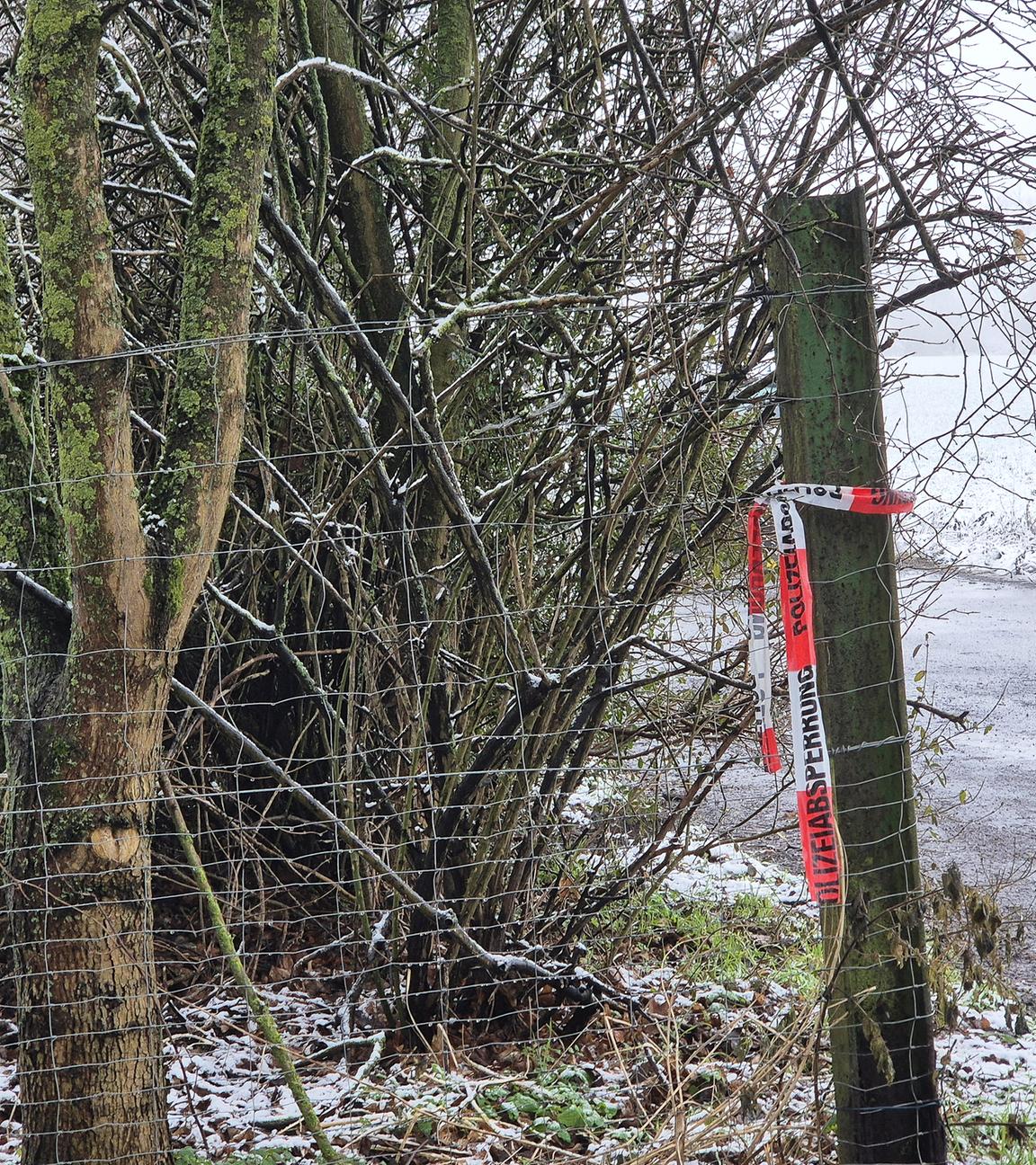 Ein Absperrband der Polizei an einem Holzpfosten.