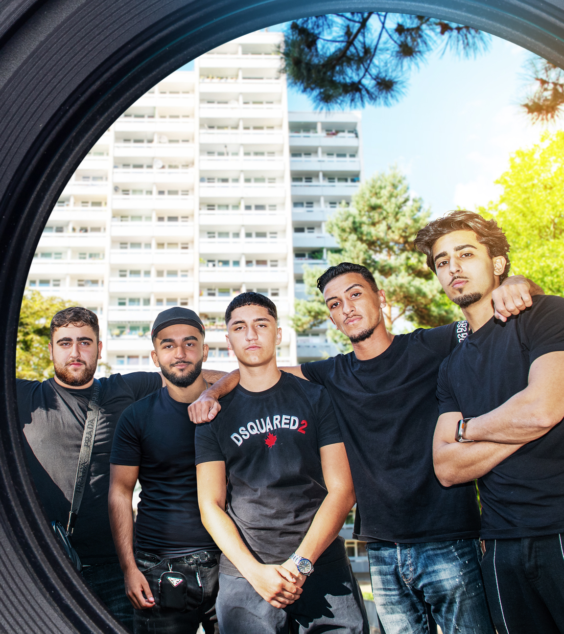 Eine Gruppe von sechs jungen Männern posiert vor einem Hochhaus.