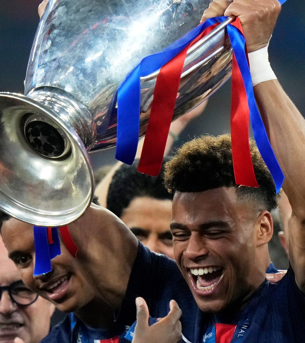 Desire Doue hält den Pokal des Champions League Finales in der Allianz Arena in München am 31.05.2025.