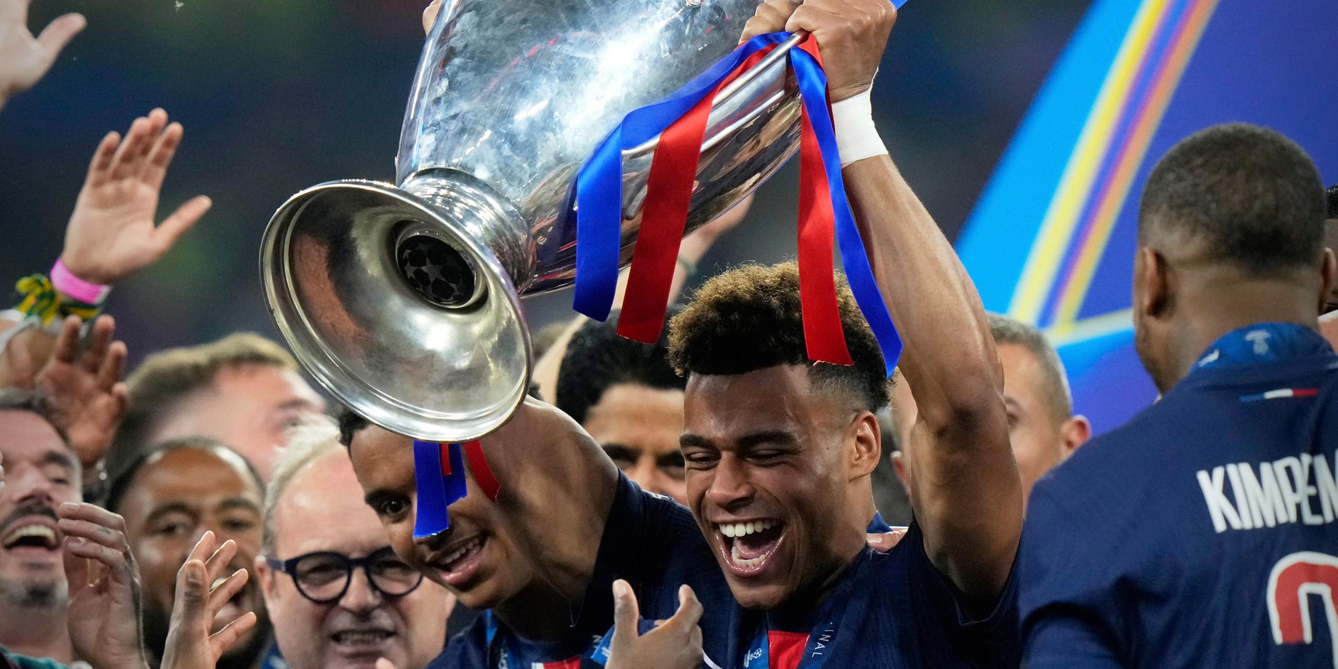 Desire Doue hält den Pokal des Champions League Finales in der Allianz Arena in München am 31.05.2025.