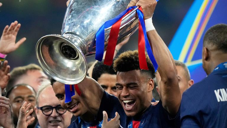 Desire Doue hält den Pokal des Champions League Finales in der Allianz Arena in München am 31.05.2025.