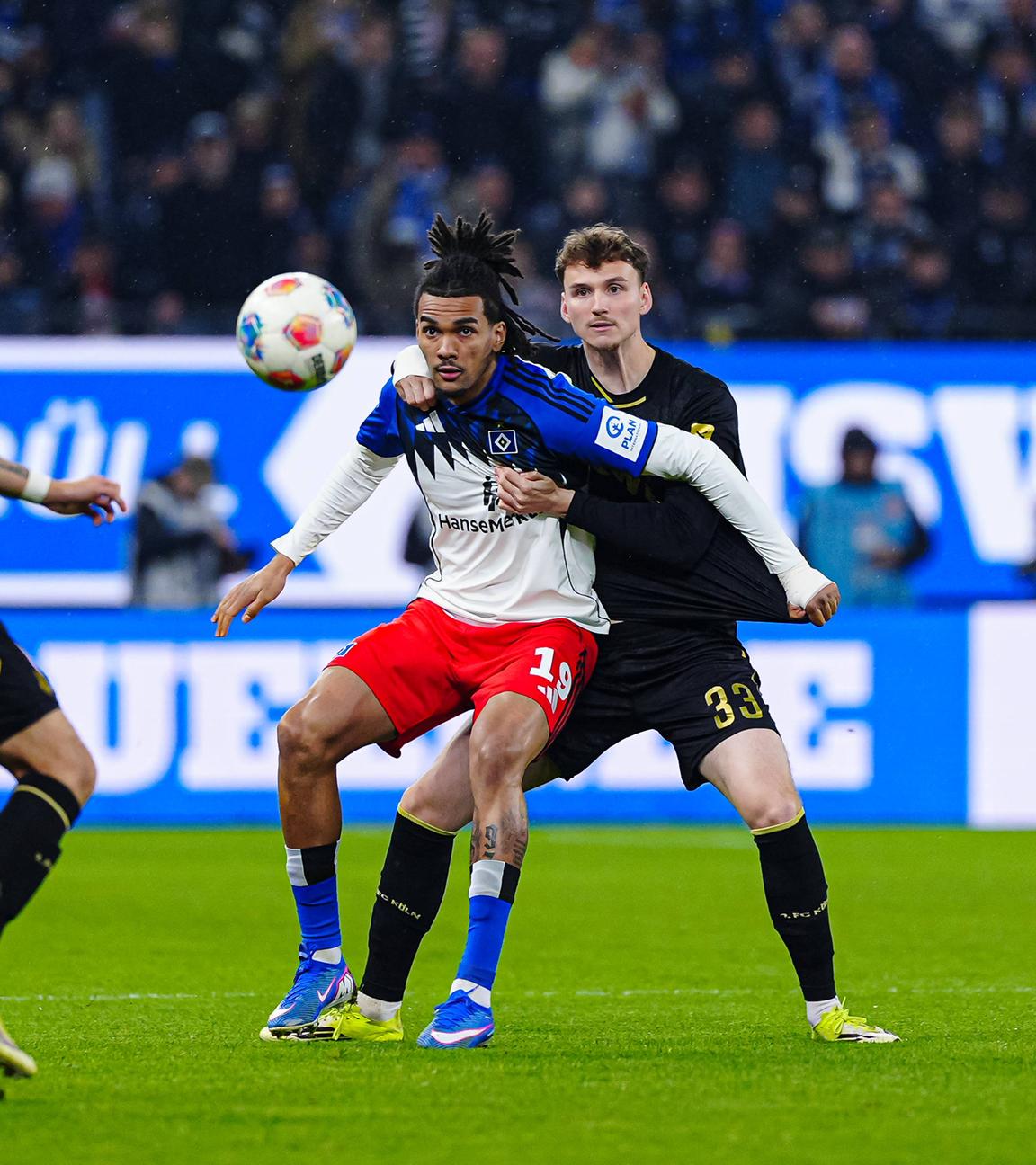 Kölns Innenverteidiger Rav van den Berg packt im Zweikampf um den Ball Hamburgs Mittelstürmer Damion Downs von hinten