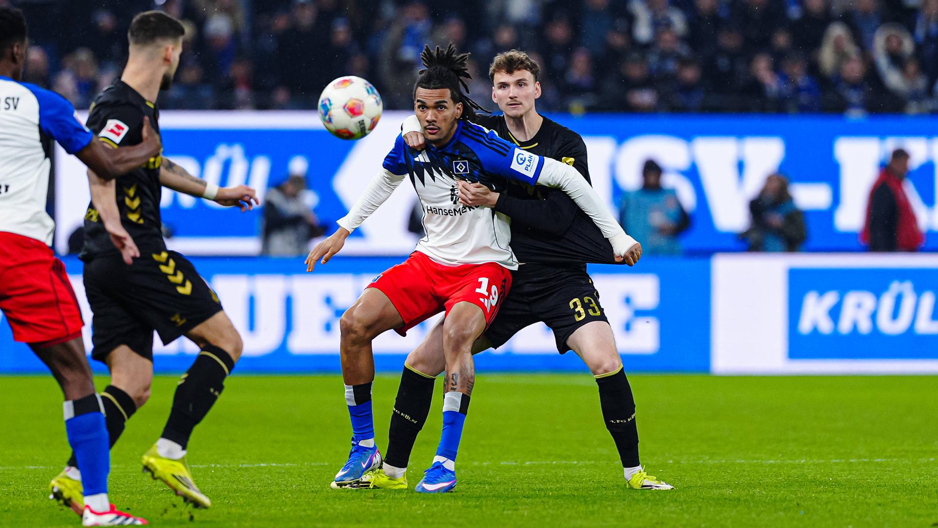 Kölns Innenverteidiger Rav van den Berg packt im Zweikampf um den Ball Hamburgs Mittelstürmer Damion Downs von hinten