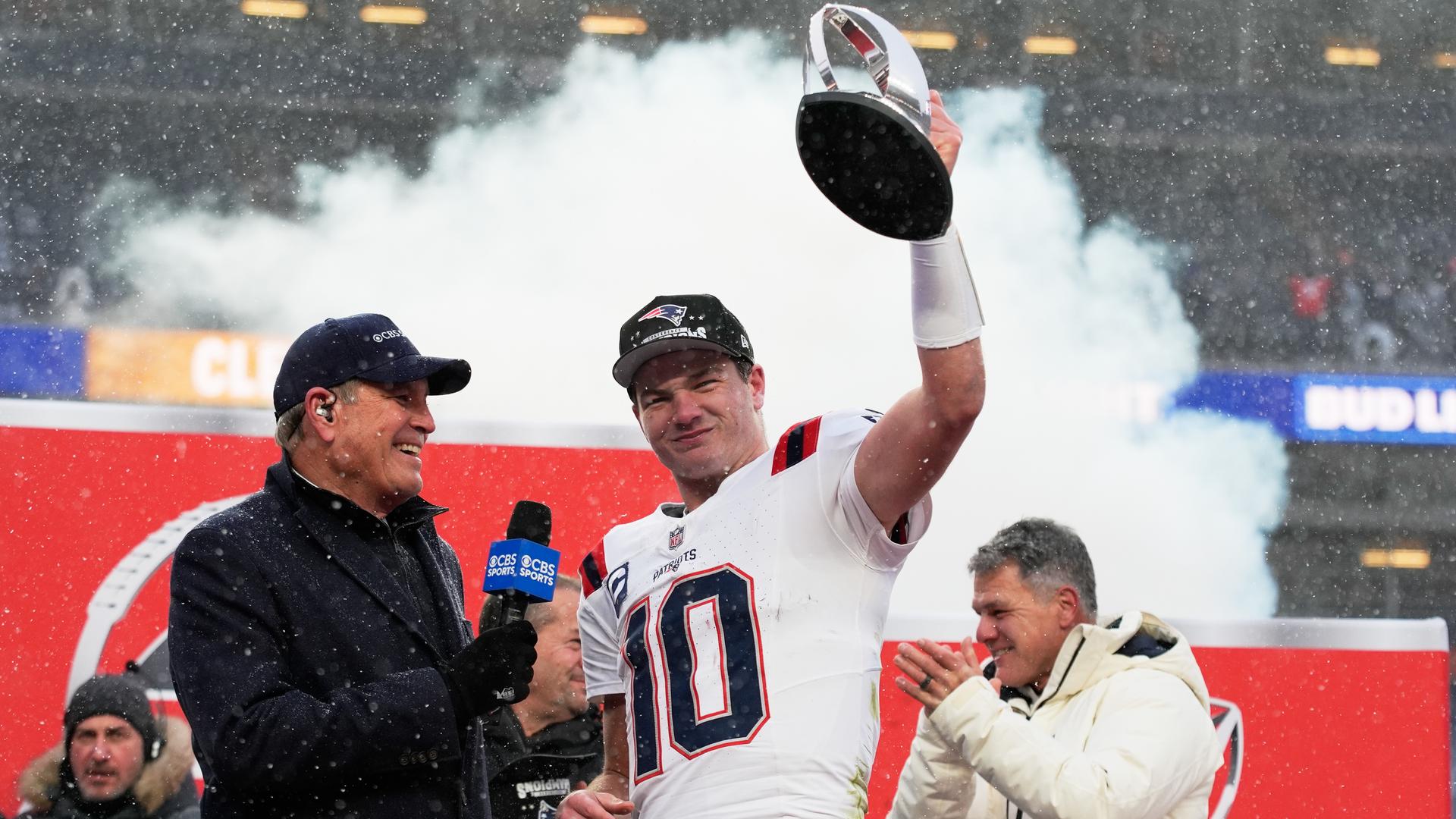 New-England-Patriots-Quarterback Drake Maye hält die Trophäe für den Gewinn des AFC-Titels in der NFL gegen die Denver Broncos in die Höhe.