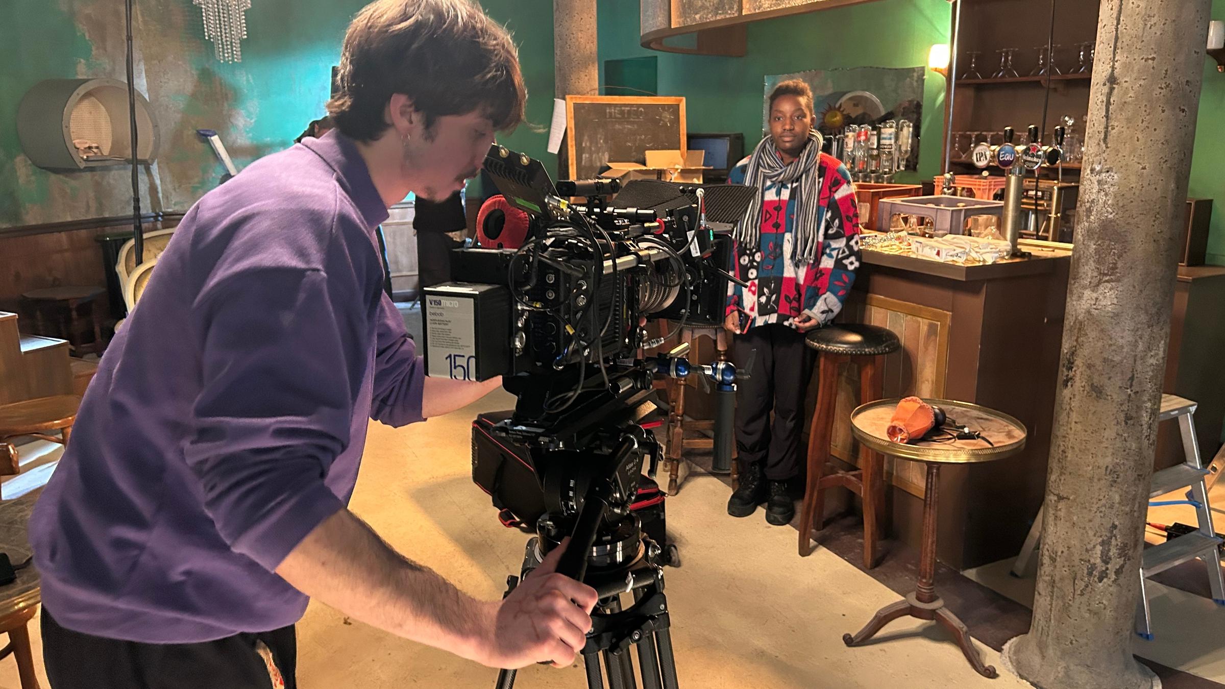 Zwei Schüler haben in einem Raum eine Kamera aufgebaut und testen das Bild.