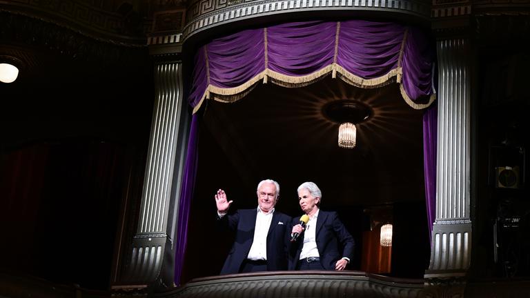 Wolfgang Kubicki und Marie-Agnes Strack-Zimmermann stehen im Opernhaus in einer Loge und sprechen ins Publikum.