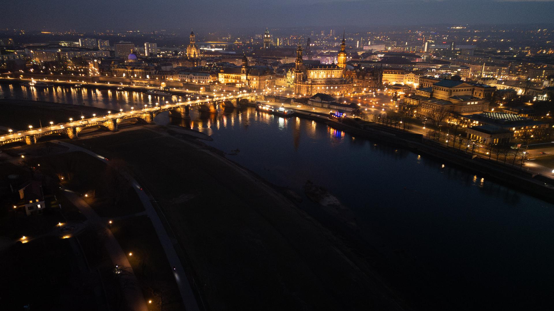 Blick am Abend auf die historische Altstadtkulisse an der Elbe mit der der Kuppel der Kunstakadmie mit dem Engel ·Fama· (l-), der Frauenkirche, dem Ständehaus, der Hofkirche, dem Rathaus, dem Hausmannsturm, der Kreuzkirche und der Semperoper. Am 13. Februar 2025 jährt sich die Zerstörung Dresdens durch anglo-amerikanische Bomben zum 80. Mal. (Luftaufnahme mit Drohne)