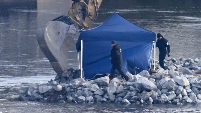 Mitarbeiter der Kampfmittelbeseitigung (KMBD) laufen vor Beginn der Entschärfung einer Weltkriegsbombe an der Fundstelle auf der Baustraße für den Abriss der Carolabrücke entlang.