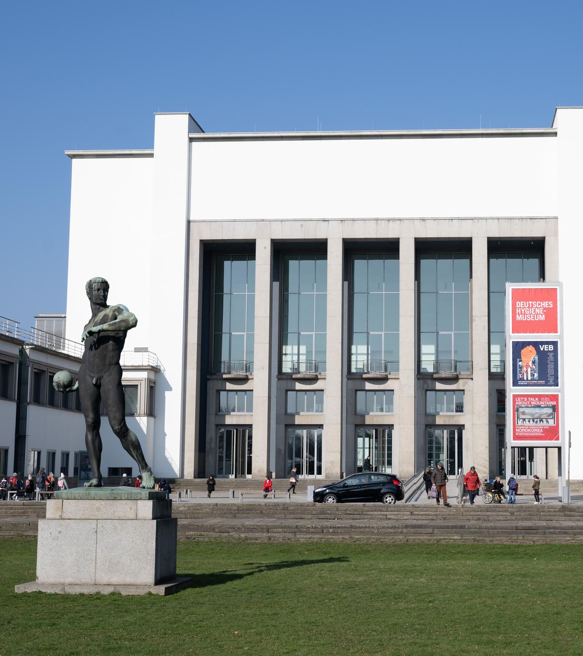 Passanten vor dem Deutschen Hygiene-Museum (DHMD) mit dem Ballwerfer von Richard Daniel Fabricius.