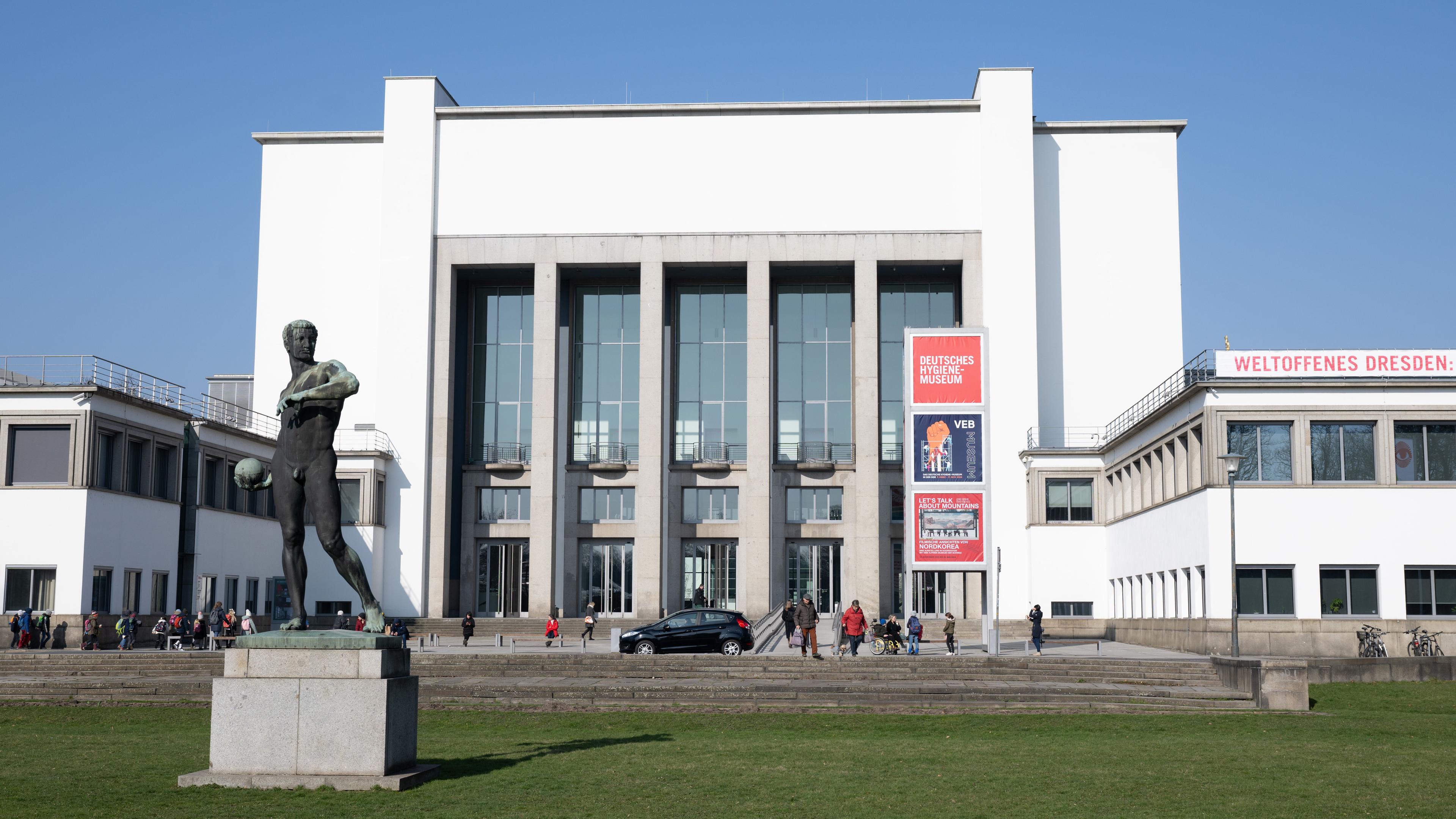 Passanten vor dem Deutschen Hygiene-Museum (DHMD) mit dem Ballwerfer von Richard Daniel Fabricius.