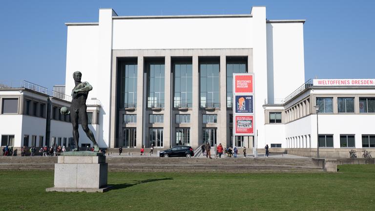 Passanten vor dem Deutschen Hygiene-Museum (DHMD) mit dem Ballwerfer von Richard Daniel Fabricius.