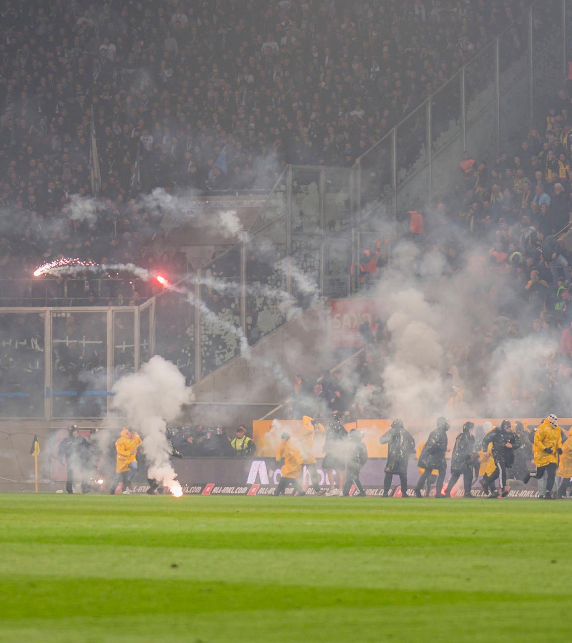 Während der Zweitligapartie zwischen Dynamo Dresden und Hertha BSC stürmen Dresdner Ultras den Platz und werfen Pyrotechnik in den Gästeblock der Berliner