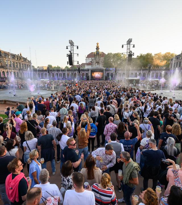 Zuschauer verfolgen das Konzert des Dresdner DJ Purple Disco Machine im Dresdner Zwinger im Innenhof.