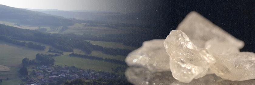 Montage: Auf der einen Seite liegt ein Dorf umgeben von Wiesen und Bäumen, auf der anderen Seite Crystal Meth in der Nahaufnahme.