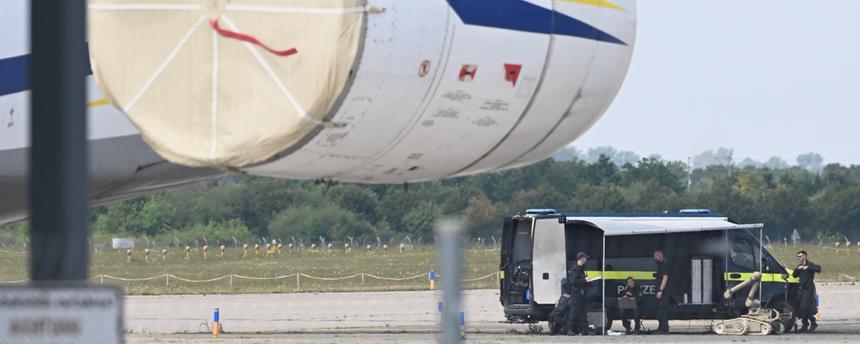 Kriminaltechniker der Polizei (hinten r) bereiten den Einsatz eines Sprengroboters in der Nähe eines ukrainischen Flugzeugs auf dem Flughafen Leipzig/Halle vor. 