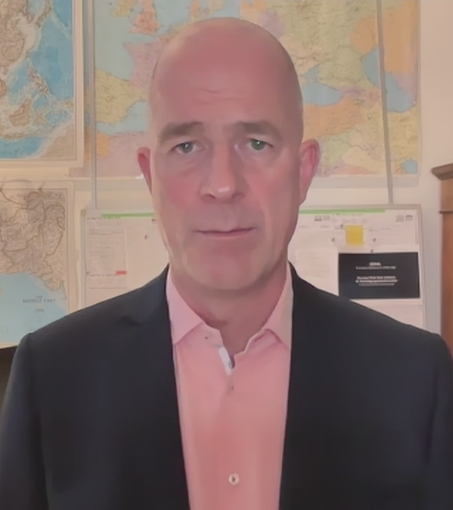 Dr. Mölling in einem Büroraum mit mehreren Weltkarten an der Wand.