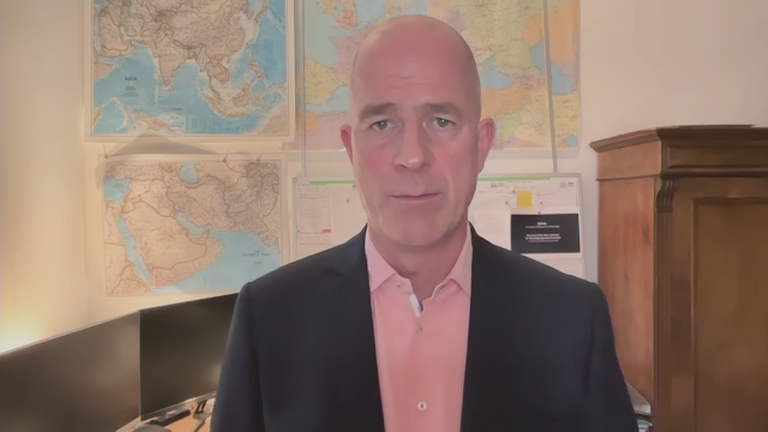 Dr. Mölling in einem Büroraum mit mehreren Weltkarten an der Wand.