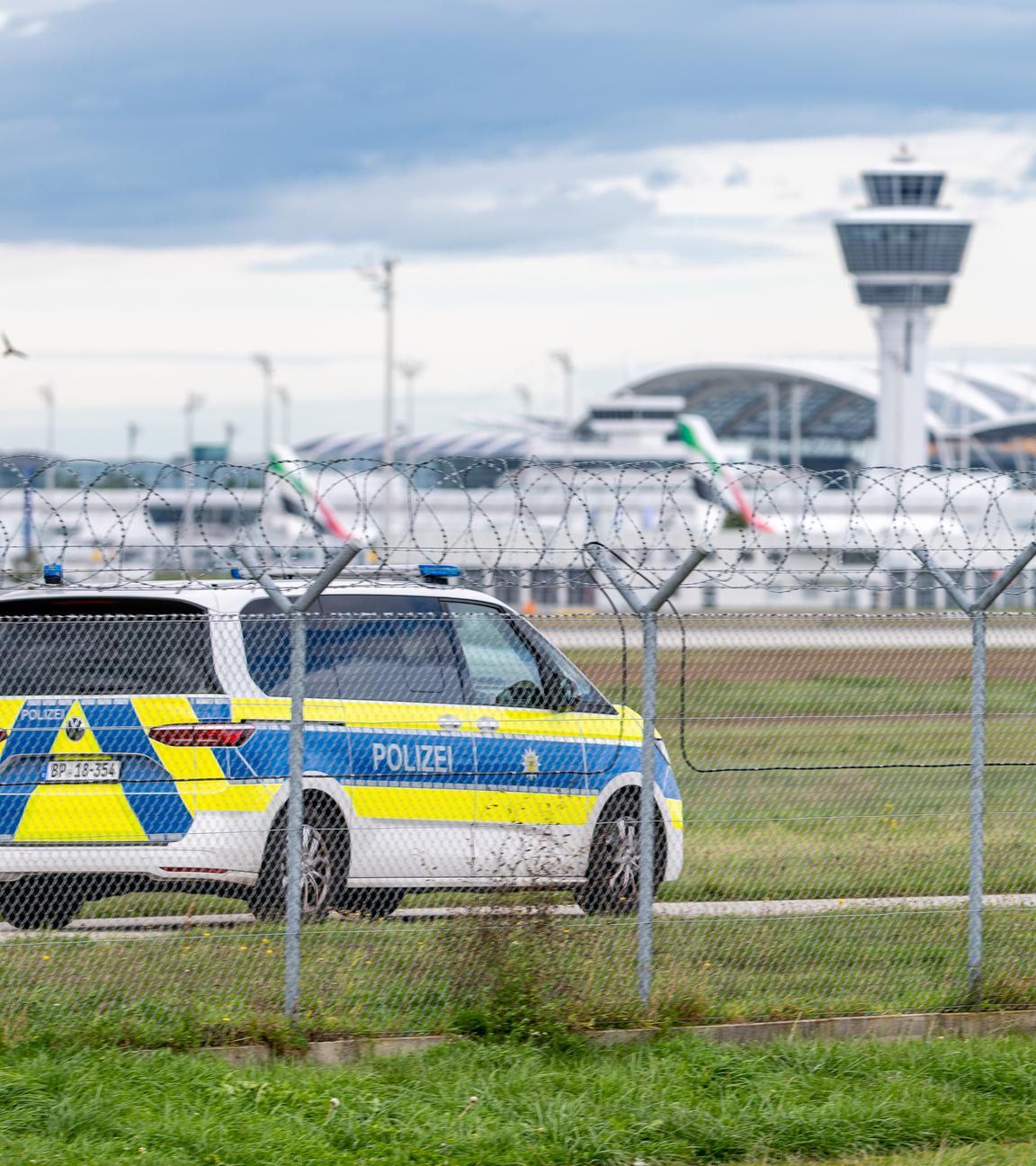 Ein Polizeifahrzeug steht am Gelände des Münchener Flughafens.