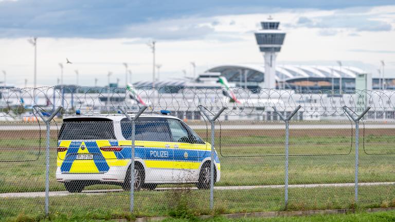 Ein Polizeifahrzeug steht am Gelände des Münchener Flughafens.