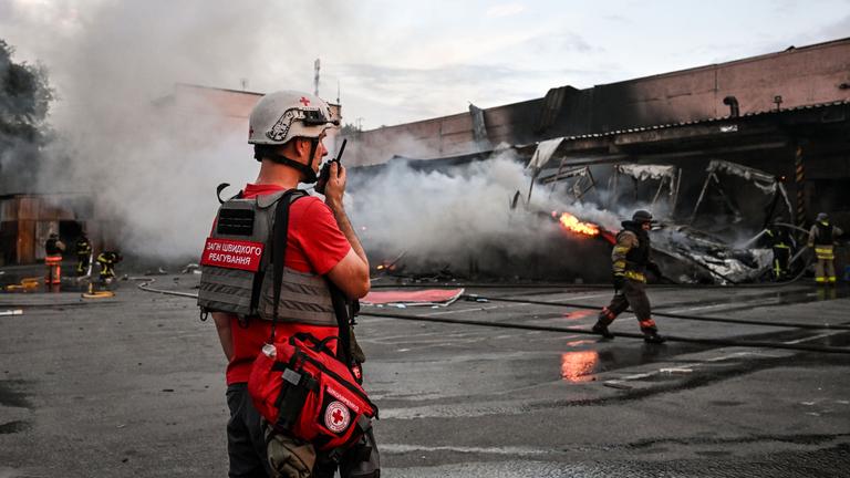 Ukrainischer Sanitäter steht vor einem Brand.