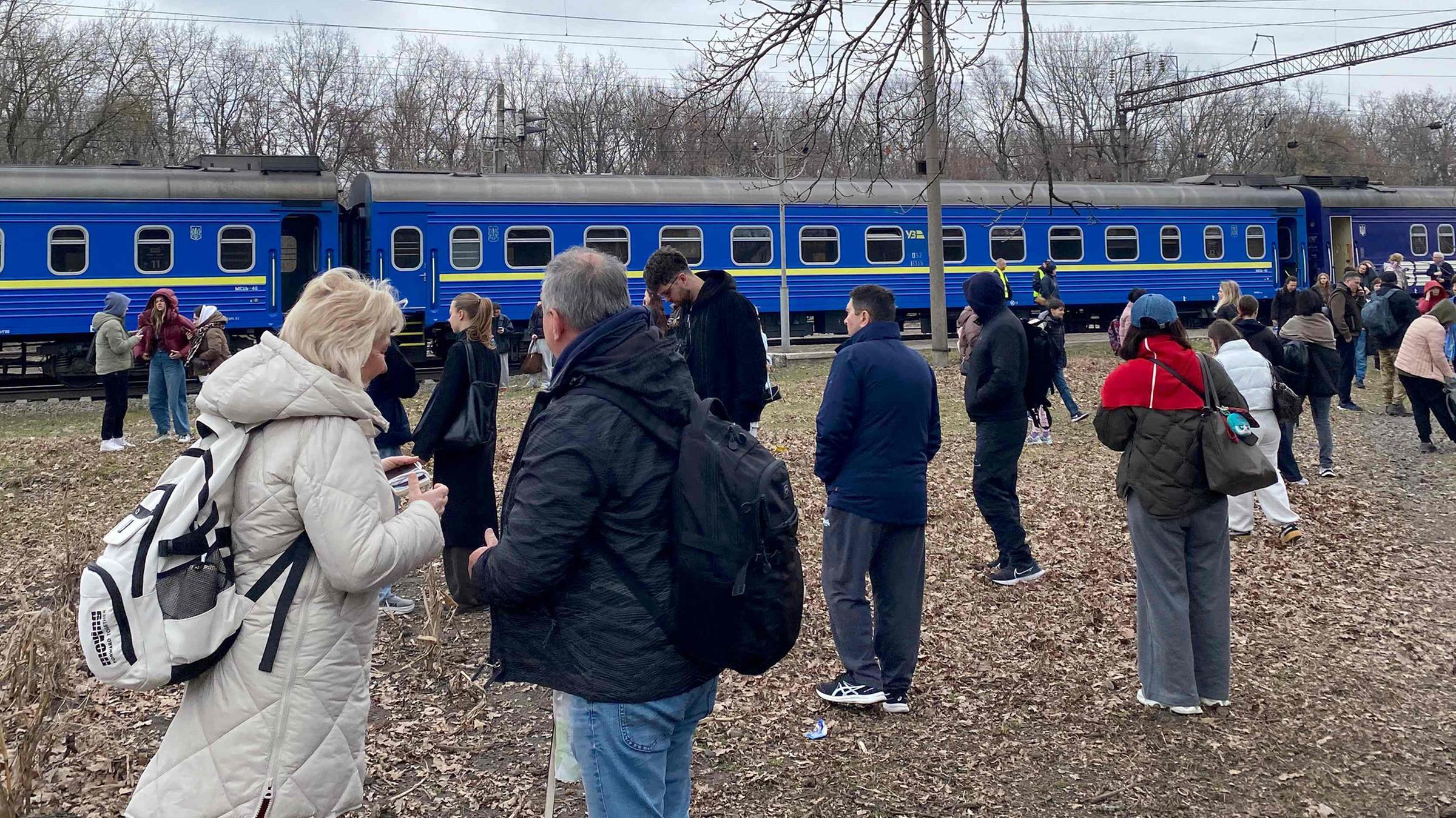 Fahrgäste warten während eines Luftalarms wegen russischer Drohnen neben ihrem Zug an einem nicht genannten Ort in der Ukraine, 29. März 2026. Die ukrainische Bahn hat nach verstärkten Angriffen auf Züge jüngst Evakuierungen eingeführt.