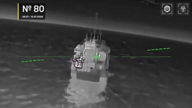 Schwarz-Weiß-Bild aus Drohnensicht bei Angriff auf Schiff.