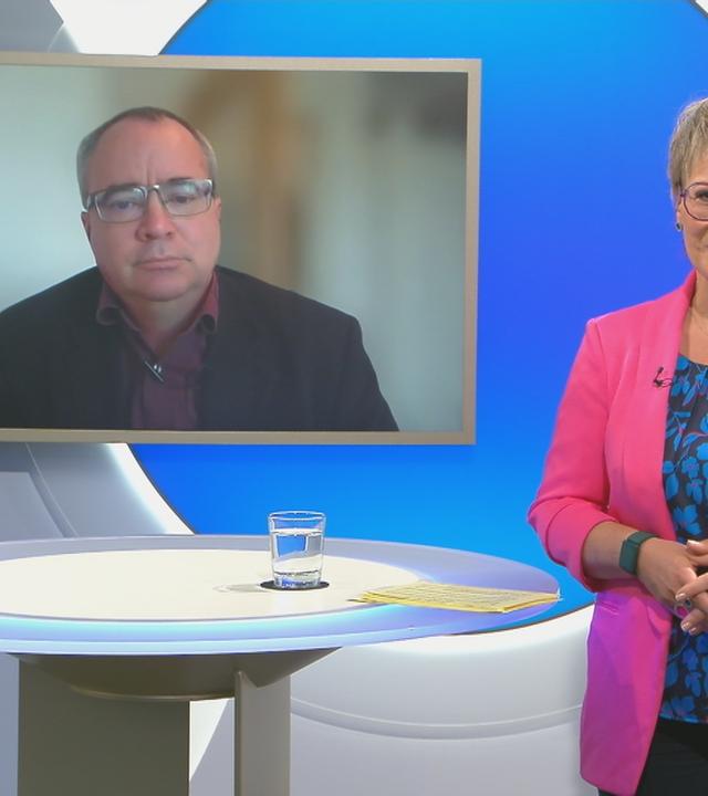 Schaltgespräch mit Andrea Ballschuh und Sönke Maahrens, der auf dem Hintergrundbildschirm zu sehen ist.