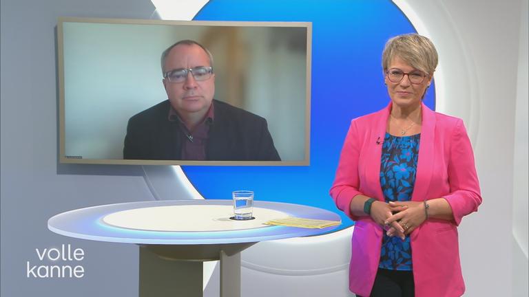 Schaltgespräch mit Andrea Ballschuh und Sönke Maahrens, der auf dem Hintergrundbildschirm zu sehen ist.