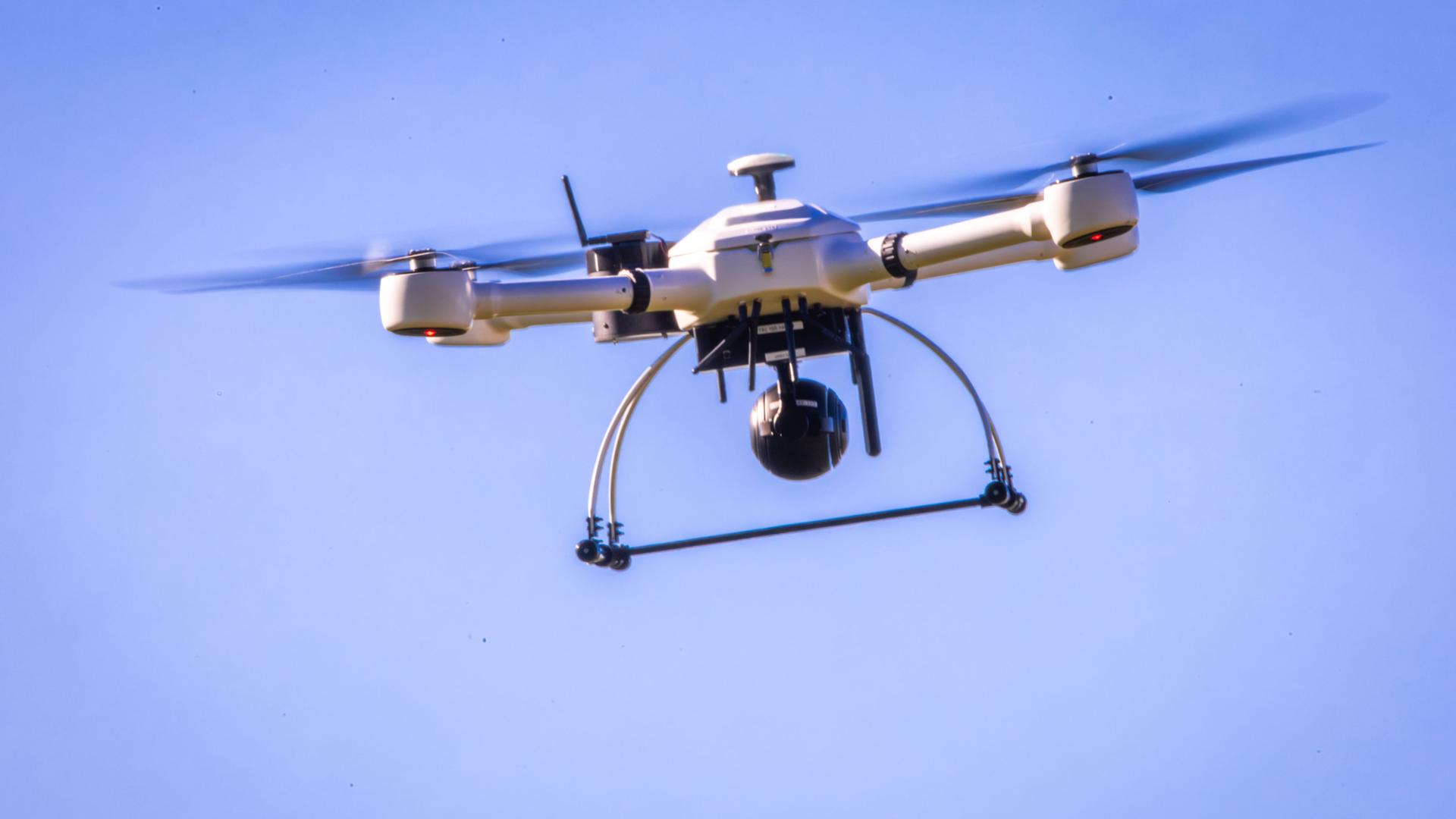 23.09.2025, Mecklenburg-Vorpommern, Rostock: Eine Drohne der Firma exabotix schwebt bei einem Praxistest für das Projekt mit dem Namen ADELE (Automatisierter Drohnen-Einsatz aus der Leitstelle) über dem künstlichen Rauch bei einem simulierten Waldbrand in der Rostocker Heide.