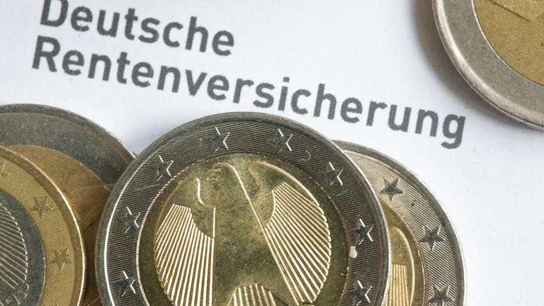 Einige Ein- und Zwei-Euro-Münzen liegen auf einer Renteninformation der Deutschen Rentenversicherung.