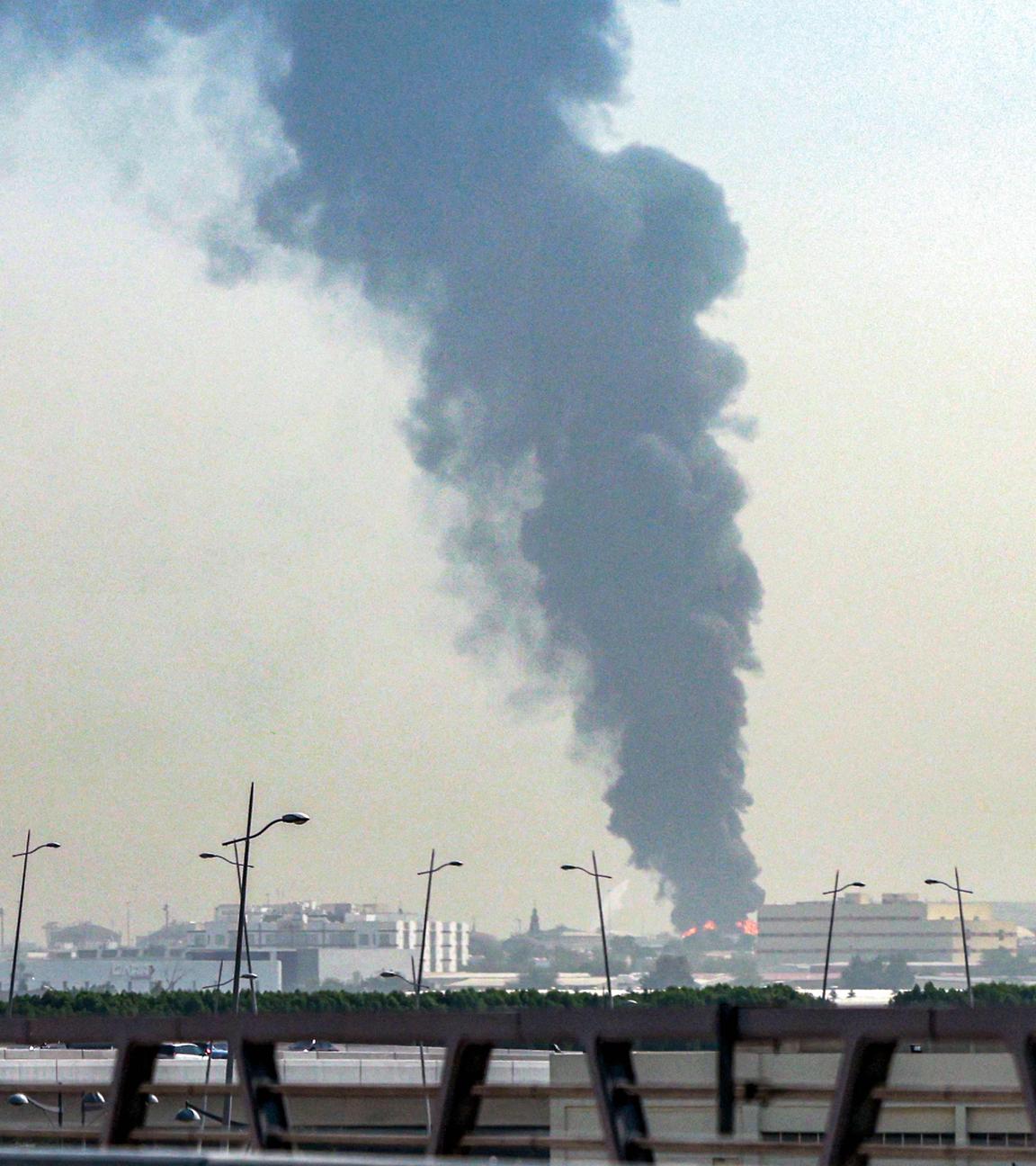 Eine dunkle Rauchwolke steigt in der Ferne auf.