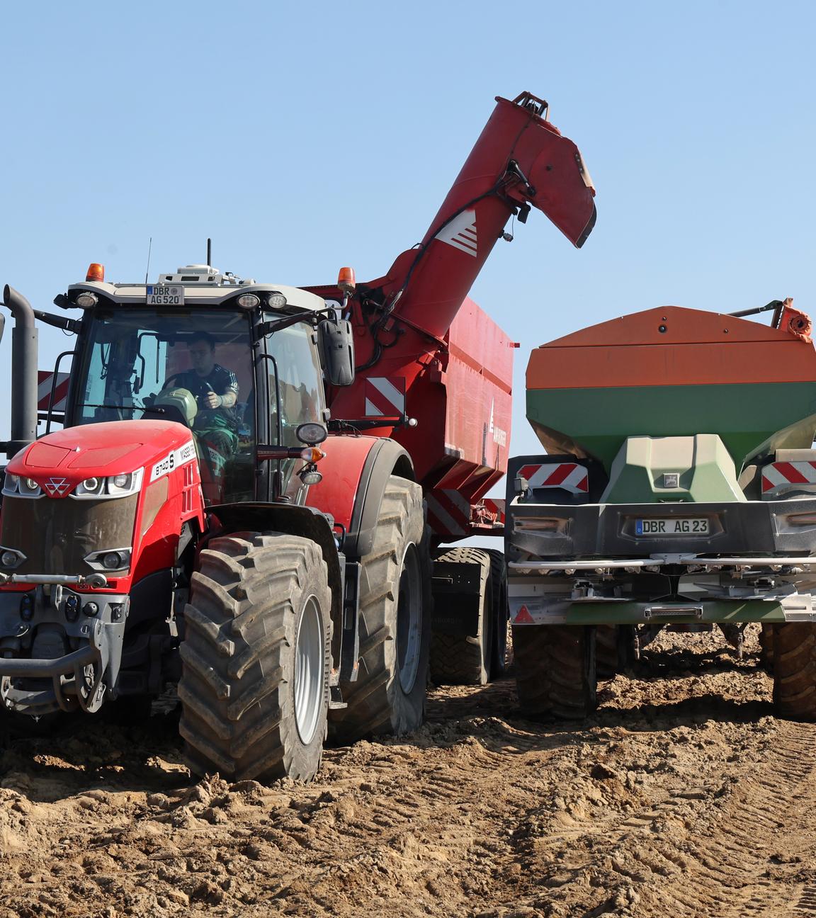 Von einem Überladewagen wird der Dünger Kornkali in einen Düngerstreuer geladen, um den späteren Anbau von Kartoffeln vorzubereiten.