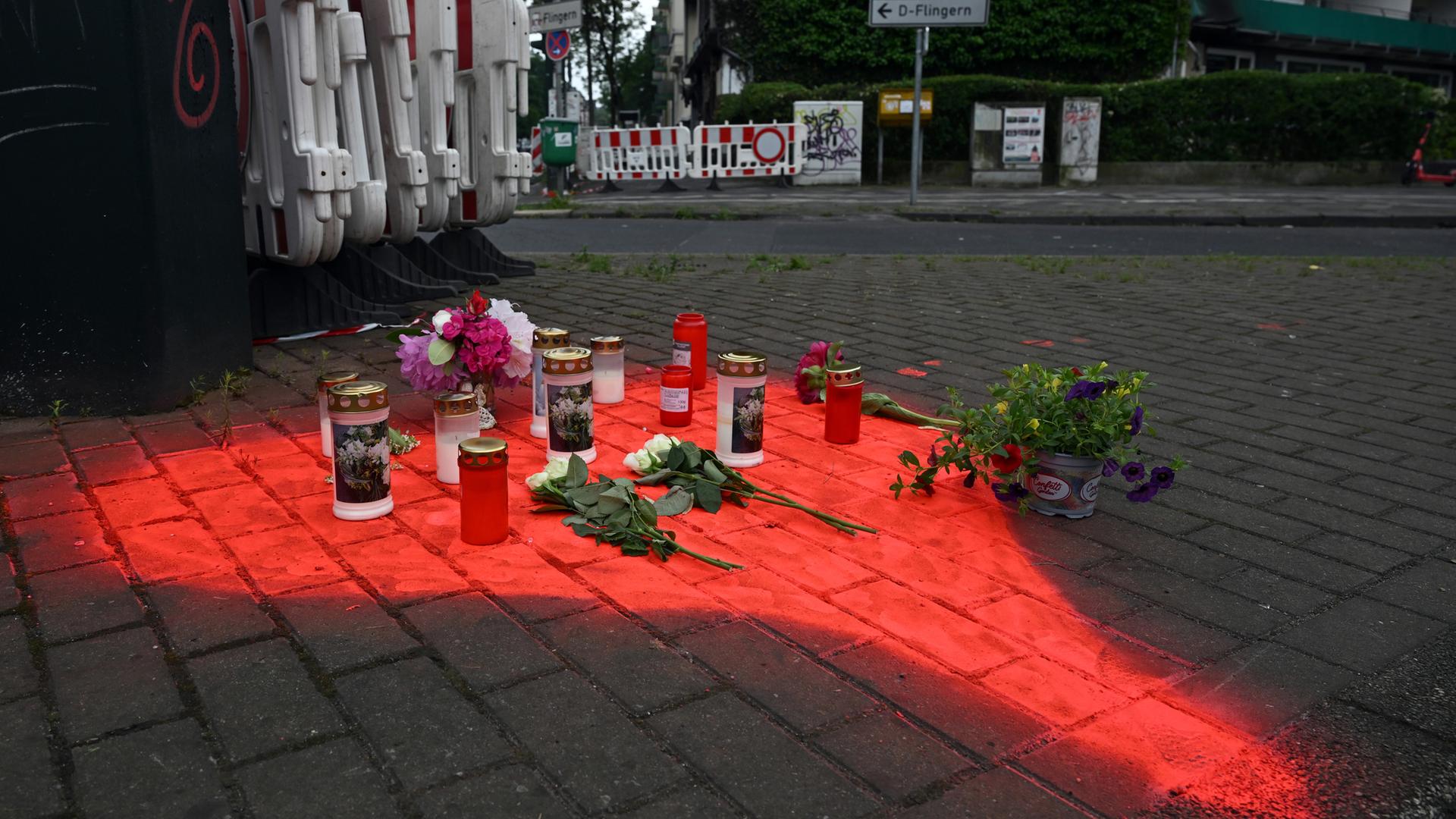 Nordrhein-Westfalen, Düsseldorf: Kerzen und Blumen liegen in einem auf das Pflaster gesprühten roten Herzen.